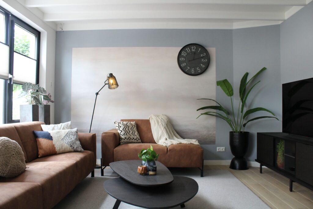 Stylish modern living room featuring cozy sofas, a wall clock, and elegant decor pieces.